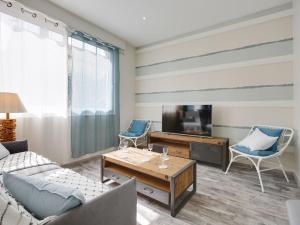 uma sala de estar com um sofá e uma televisão em Apartment Terre et Mer-1 by Interhome em Arcachon