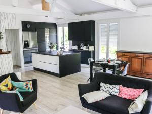 una cucina e un soggiorno con mobili bianchi e neri di Holiday Home Crabot by Interhome a Saint-Vivien-de-Médoc