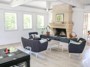 un soggiorno con camino, tavolo e sedie di Holiday Home Crabot by Interhome a Saint-Vivien-de-Médoc