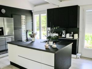 una cucina con armadi neri e piano di lavoro nero di Holiday Home Crabot by Interhome a Saint-Vivien-de-Médoc Altre 15 foto