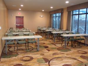 an empty room with tables and chairs and windows at Cobblestone Inn & Suites - Marquette in Marquette