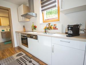 a kitchen with white cabinets and a sink and a window at Apartment Mundlers Hoamatl Top 1 by Interhome in Oetz
