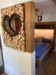 um quarto com uma cama com uma parede de troncos em Ferienwohnung Königsberger Klosterblick em Ettal