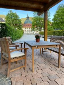 einen Holztisch und zwei Stühle auf einer Terrasse in der Unterkunft Ferienwohnung Königsberger Klosterblick in Ettal