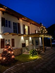 ein Haus mit Weihnachtsbäumen und Lichtern im Hof in der Unterkunft Ferienwohnung Königsberger Klosterblick in Ettal