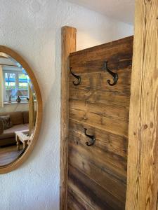 a wall with a wooden door with a mirror at Ferienwohnung Königsberger Klosterblick in Ettal