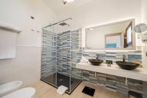 a bathroom with two sinks and a glass shower at Hotel Ristorante La Conchiglia in Cala Gonone