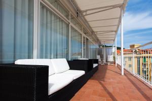 a white couch on the balcony of a building at Hotel Mainè in Finale Ligure