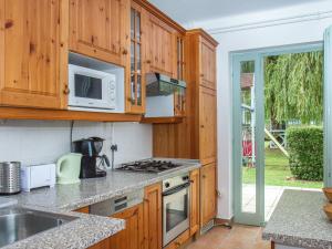 a kitchen with wooden cabinets and a stove top oven at Holiday Home Sapphire by Interhome in Balatonmáriafürdő
