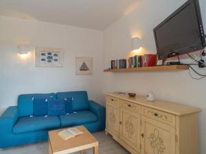 un soggiorno con un divano blu e una TV di Apartment Trudi by Interhome a Cannigione
