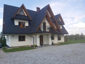 una casa con techo negro en una entrada de grava en PRZY LESIE, en Bukowina Tatrzańska