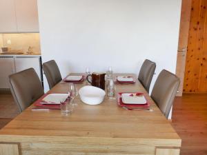 einem Esstisch mit Stühlen und einem Holztisch in der Unterkunft Apartment Chaedoz 36 by Interhome in Nendaz