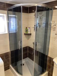 a shower with a glass door in a bathroom at Superubytovanie Olga in Štrba