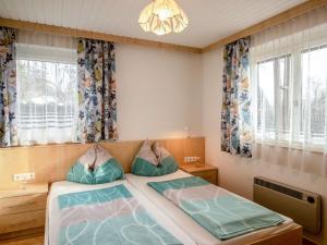 a bedroom with two beds and a chandelier at Holiday Home Laube by Interhome in Sankt Kanzian