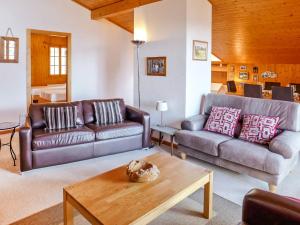 a living room with two leather couches and a coffee table at Apartment Armorial II - apt 6 by Interhome in Villars-sur-Ollon