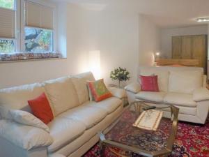 ein Wohnzimmer mit einem weißen Sofa und einem Tisch in der Unterkunft Apartment Donau by Interhome in Donaueschingen