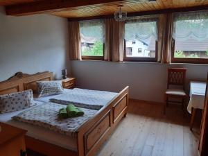 a bedroom with two beds and a desk and windows at Ferienwohnung Johanna in Sankt Georgen im Gailtal