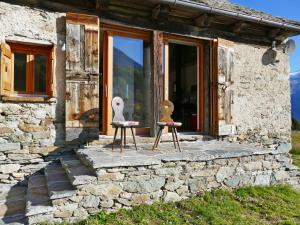 zwei Holzstühle vor einem Gebäude in der Unterkunft Holiday Home Rustico Andrea by Interhome in Acquarossa