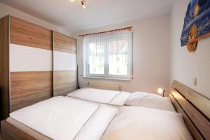 a bedroom with a large white bed with a window at Ferienwohnung am Potenberg FeWo 6 - Balkon in Binz