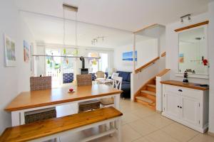 a kitchen and living room with a dining room table at Ferienhaus Cumulus Haus - strandnah, Terrasse, Sauna in Drewoldke