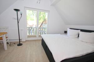 1 dormitorio con cama, escritorio y ventana en Ferienhaus Cumulus Haus - strandnah, Terrasse, Sauna en Drewoldke