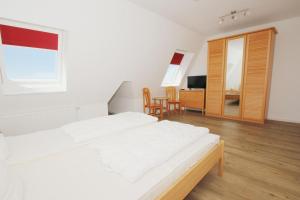 TV a/nebo společenská místnost v ubytování hafennahe Ferienwohnung mit Balkon und Meerblick - Hafenhäuser Wiek Wohnung 17