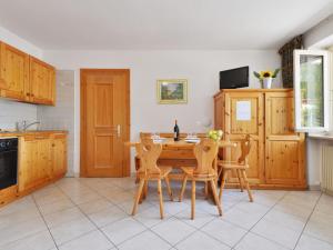 a kitchen with a wooden table and chairs at Apartment Villa Placidia Apt 22 by Interhome in Campitello di Fassa