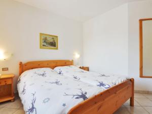 a bedroom with a bed with a blue and white comforter at Apartment Villa Placidia Apt 22 by Interhome in Campitello di Fassa +25 photos