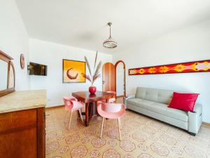 ein Wohnzimmer mit einem Sofa, einem Tisch und Stühlen in der Unterkunft Apartment Pinta by Interhome in Caronia Marina