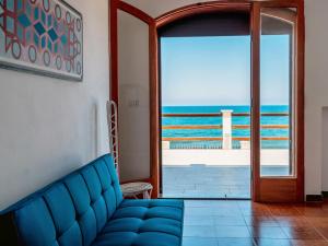 ein blaues Sofa in einem Zimmer mit Meerblick in der Unterkunft Apartment Nina by Interhome in Caronia Marina