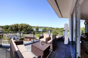 a balcony with chairs and tables and a view at Residenz Seeterrassen FeWo9 - Balkon, Seeblick, Sauna in Binz