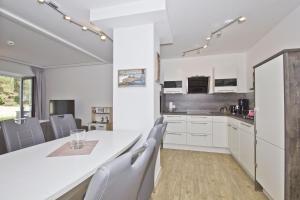 a kitchen with white cabinets and a table and chairs at Ostseeresort Binz Prora in Binz