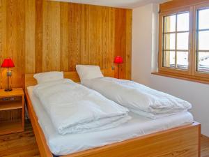 a bedroom with two beds with white sheets and a window at Apartment Bergere-2 by Interhome in Zermatt