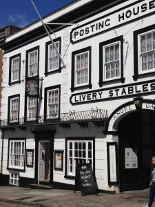 un edificio blanco con un cartel delante en The Angel Posting House & Livery en Guildford