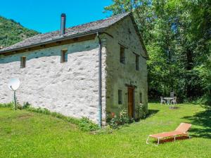 een oud stenen huis met een bankje ervoor bij Holiday Home Rustico al Campett by Interhome in Ponto Valentino