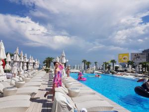 a woman standing next to a pool at a resort at Sunrise Arcadia Sky in Odesa