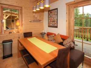 ein Esszimmer mit einem Holztisch und einem Sofa in der Unterkunft Chalet Almhaus Galisch by Interhome in Sirnitz-Sonnseite
