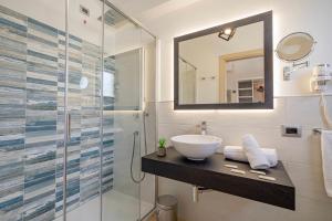 a bathroom with a sink and a glass shower at Hotel Ristorante La Conchiglia in Cala Gonone
