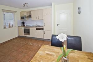 une cuisine avec une table et des chaises dans une pièce dans l'établissement zentral aber ruhig, Balkon, gratis Nutzung vom AHOI Erlebnisbad und Sauna in Sellin - Villa Elisenhof FeWo 2, à Göhren