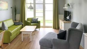 a living room with a green couch and chairs at Terrasse, gratis Nutzung vom AHOI Erlebnisbad und Sauna - Meeresblick FeWo 10 in Göhren
