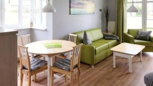 a living room with a green couch and a table at Terrasse, gratis Nutzung vom AHOI Erlebnisbad und Sauna - Meeresblick FeWo 10 in Göhren