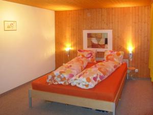 uma cama com almofadas num quarto em Apartment Fortuna by Interhome em Grächen