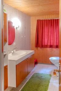 uma casa de banho com um lavatório e uma cortina vermelha em Apartment Fortuna by Interhome em Grächen