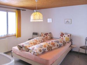um quarto com uma cama com almofadas em Apartment Fortuna by Interhome em Grächen