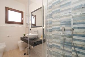 a bathroom with a sink and a glass shower at Hotel Ristorante La Conchiglia in Cala Gonone