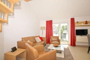 a living room with a couch and a table at Strandresort Rex Rugia Ferienwohnung 14-6 mit Sauna- und Schwimmbadnutzung im AHOI Sellin in Lobbe