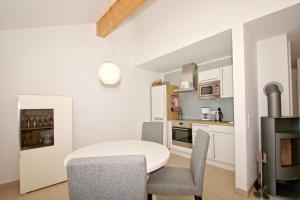 a kitchen and dining room with a table and chairs at Strandresort Rex Rugia Ferienwohnung 14-6 mit Sauna- und Schwimmbadnutzung im AHOI Sellin in Lobbe