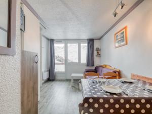uma sala de estar com uma mesa e um sofá em Apartment La Boédette-7 by Interhome em Les Menuires