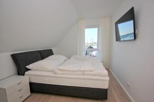 a small bedroom with a bed and a window at Ferienhaus TimpeTe Haus Backbord - Terrasse, Meerblick, Sauna in Gager