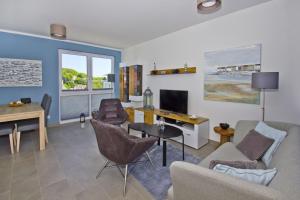 ein Wohnzimmer mit einer Couch, einem Tisch und einem Fernseher in der Unterkunft zentrale FeWo mit Balkon, gratis Nutzung vom AHOI Erlebnisbad und Sauna in Sellin - Villa Anni FeWo 05 in Göhren